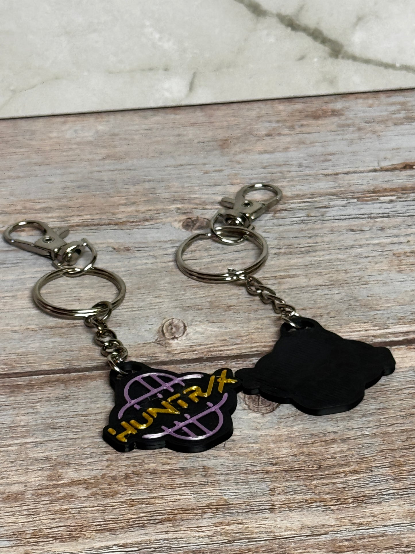 HUNTRX Acrylic Keychain – Purple & Gold Logo with Holographic Back